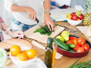Woman cutting healthy fruits and vegetables
